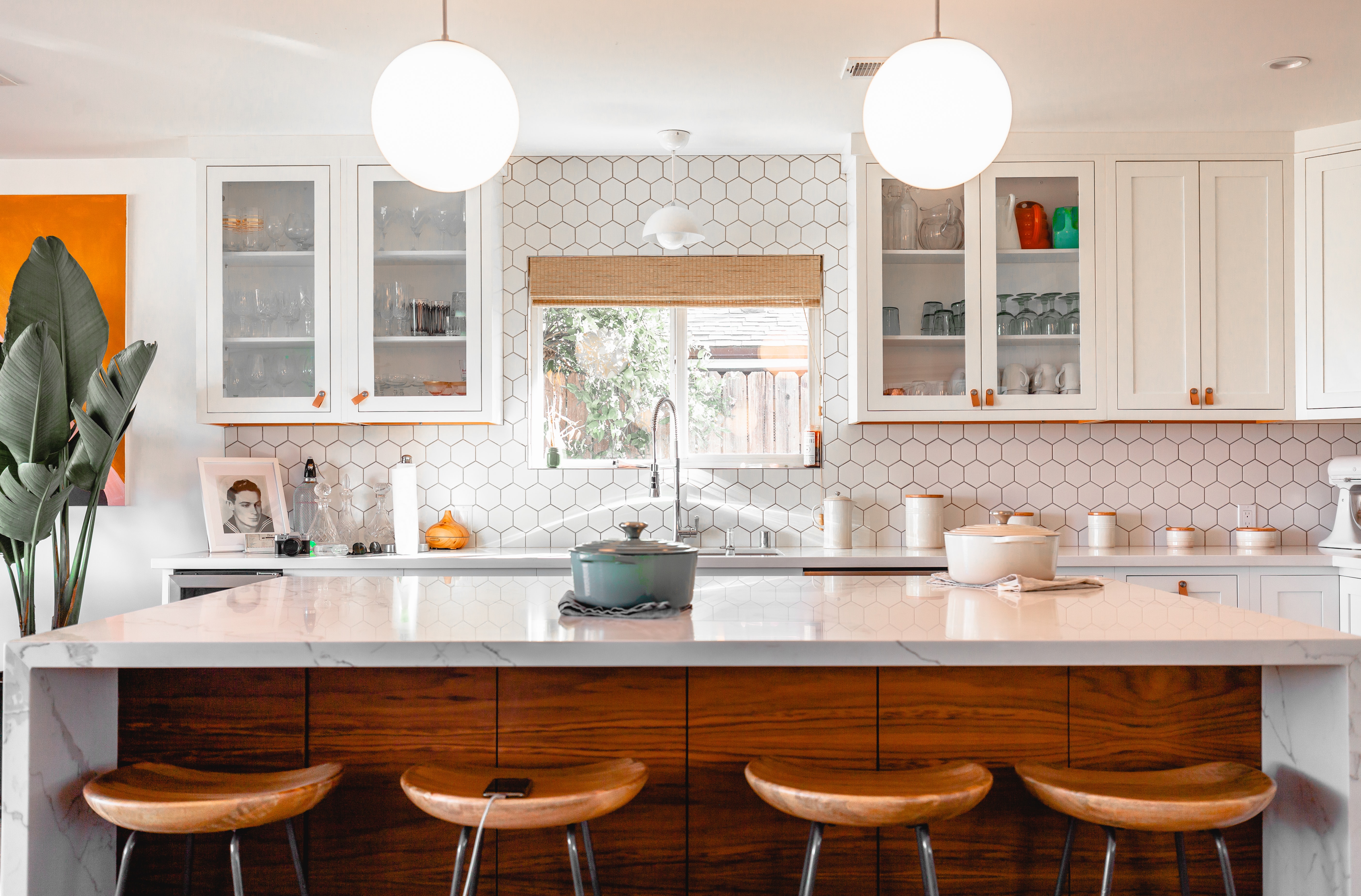 Bright modern kitchen with white cabinetry and marble island