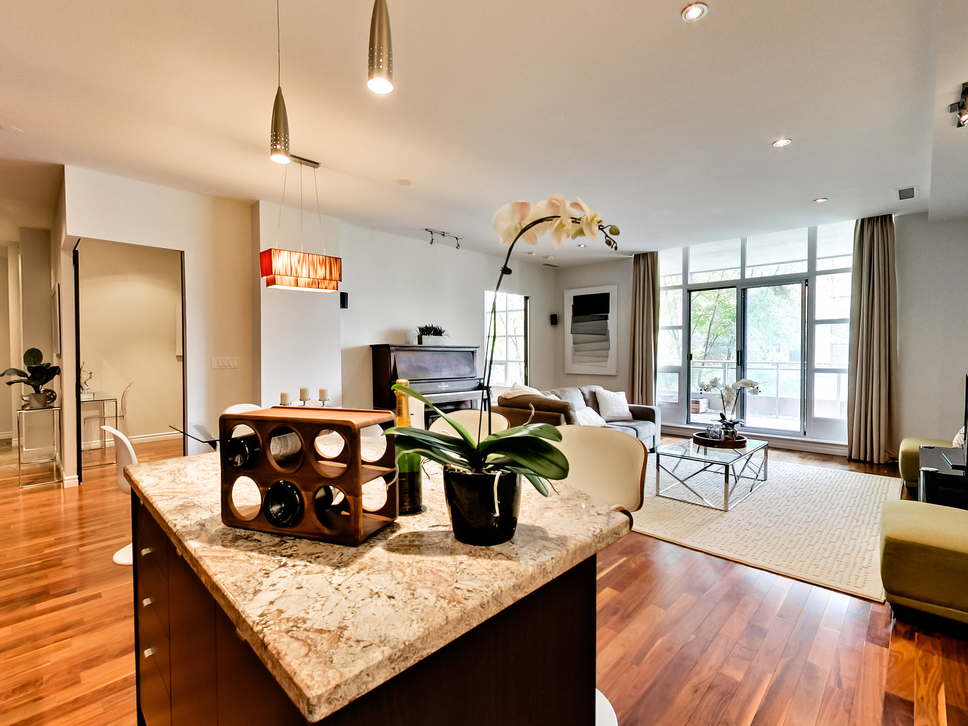 Open-concept condo with a granite kitchen island and bright living area