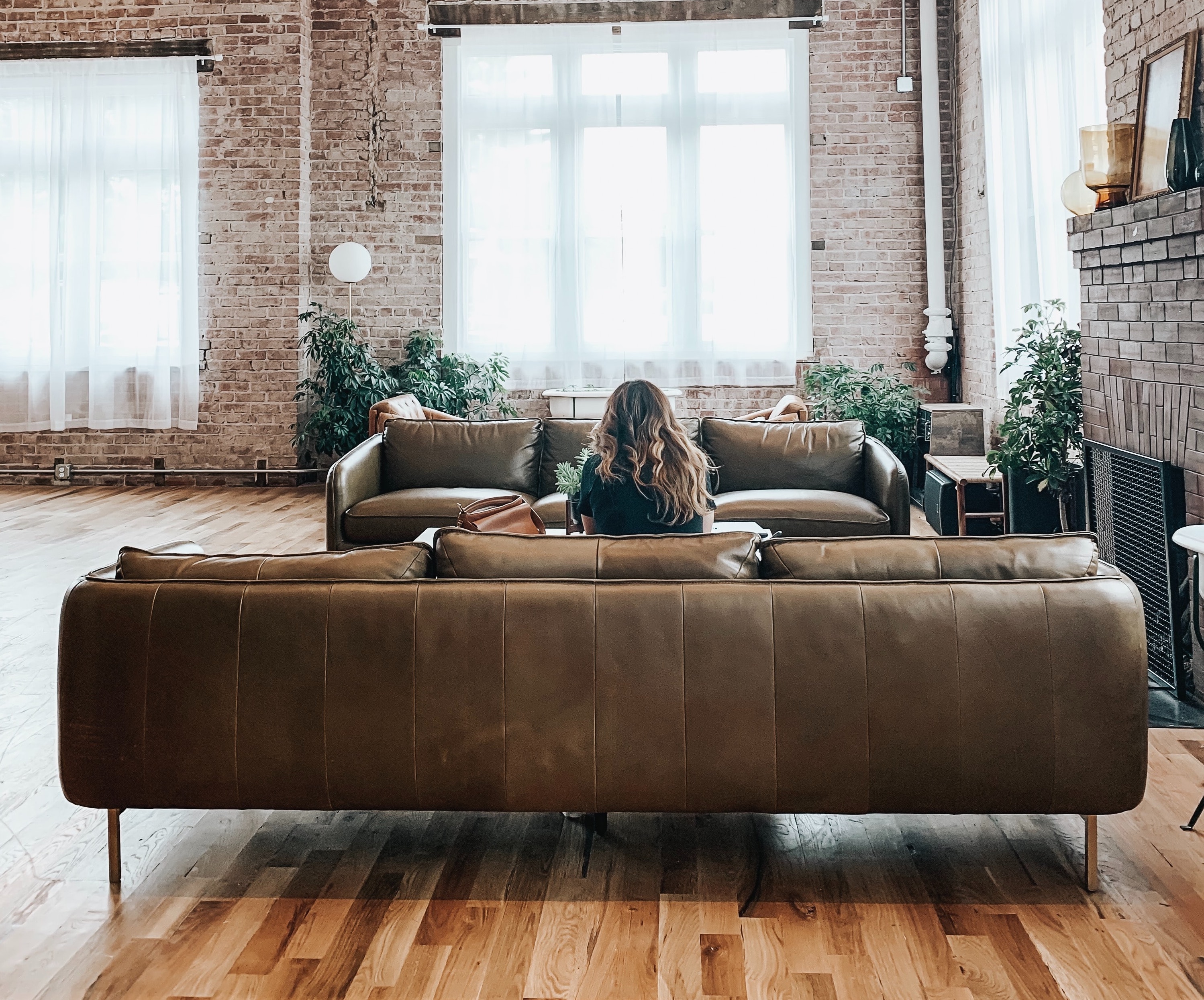 Woman relaxing on a leather sofa in a bright loft